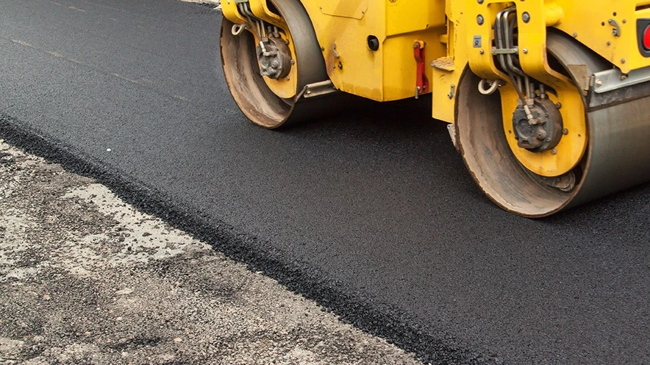 A steam roller over fresh asphalt.