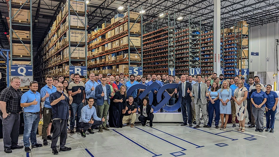 a group of people pose in a warehouse